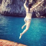 Whitney Cummings jumping off a boat in a bikini