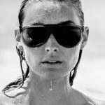 Elsa Hosk dripping wet with water on the beach in sunglasses