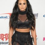 Demi Lovato in a black sheer top and matching pants