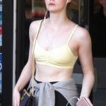 Elle Fanning in a yellow sports bra and a sweater