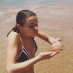 Joey King holds a jellyfish in a swimsuit