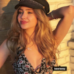 Ryan Whitney Newman posing in the sun with a cap on