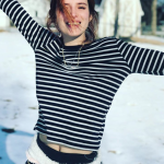 Bella Thorne in a black and white sripped christmas sweater