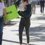 Ashley Tisdale wearing a green sweater hiding her face