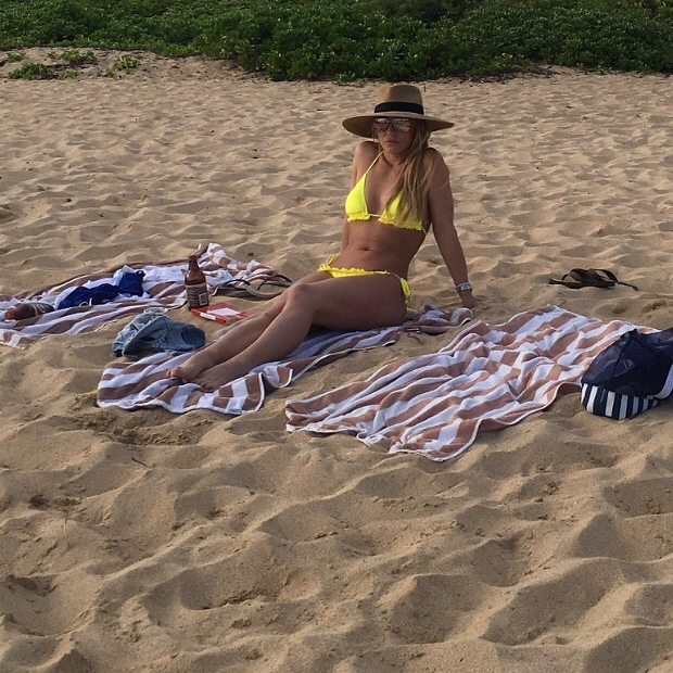Britney Spears lays down on the beach in a tiny yellow bikini