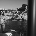 Emilie Payet posing on a boat topless