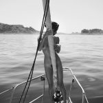 Emilie Payet standing nude on a boat