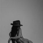 Kera Lester sits naked in a hat