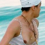 Michelle Rodriguez lets her nipple fall out of her bikini on the beach