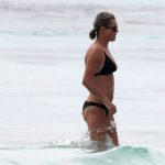 Rebecca Romijn has her hands in her black bikini bottoms