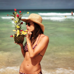 Alessandra Ambrosio sucks a straw in her bikini on the beach