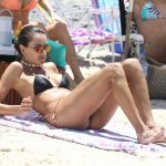 Alessandra Ambrosio lays on the beach in her bikini