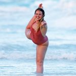 Iskra Lawrence in a red swimsuit getting wet