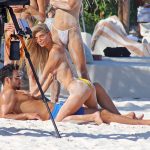 Danielle Knudson topless on top of a male model on the beach