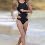 Elle Macpherson runs in a black tight bikini