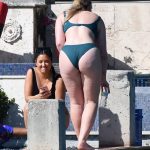 Iskra Lawrence bends over in a tight green bikini