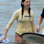 Kira Kosarin surfing in a wet t shirt