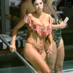 Nicole Murphy in a pink bikini getting wet in the pool