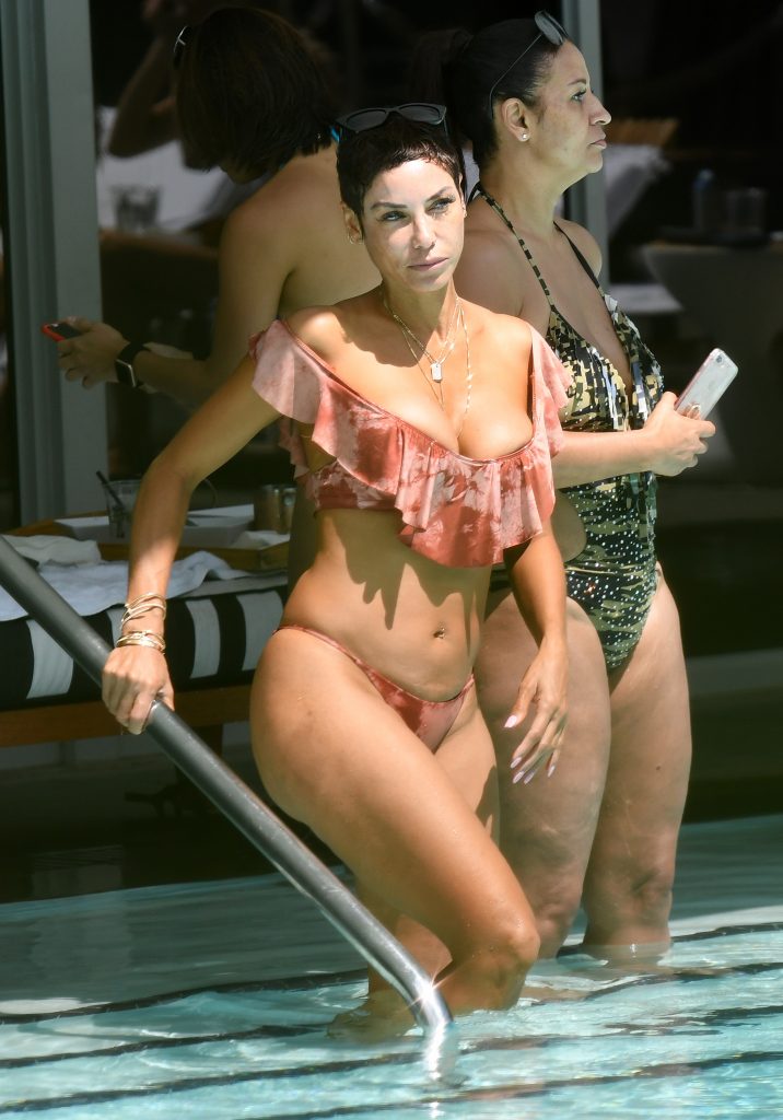Nicole Murphy in a pink bikini getting wet in the pool