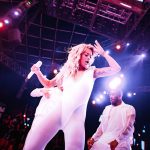 Rita Ora on stage in a tight white bodysuit