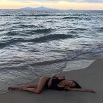 nicole scherzinger big fake tits in a black cut out bikini laying in the sand